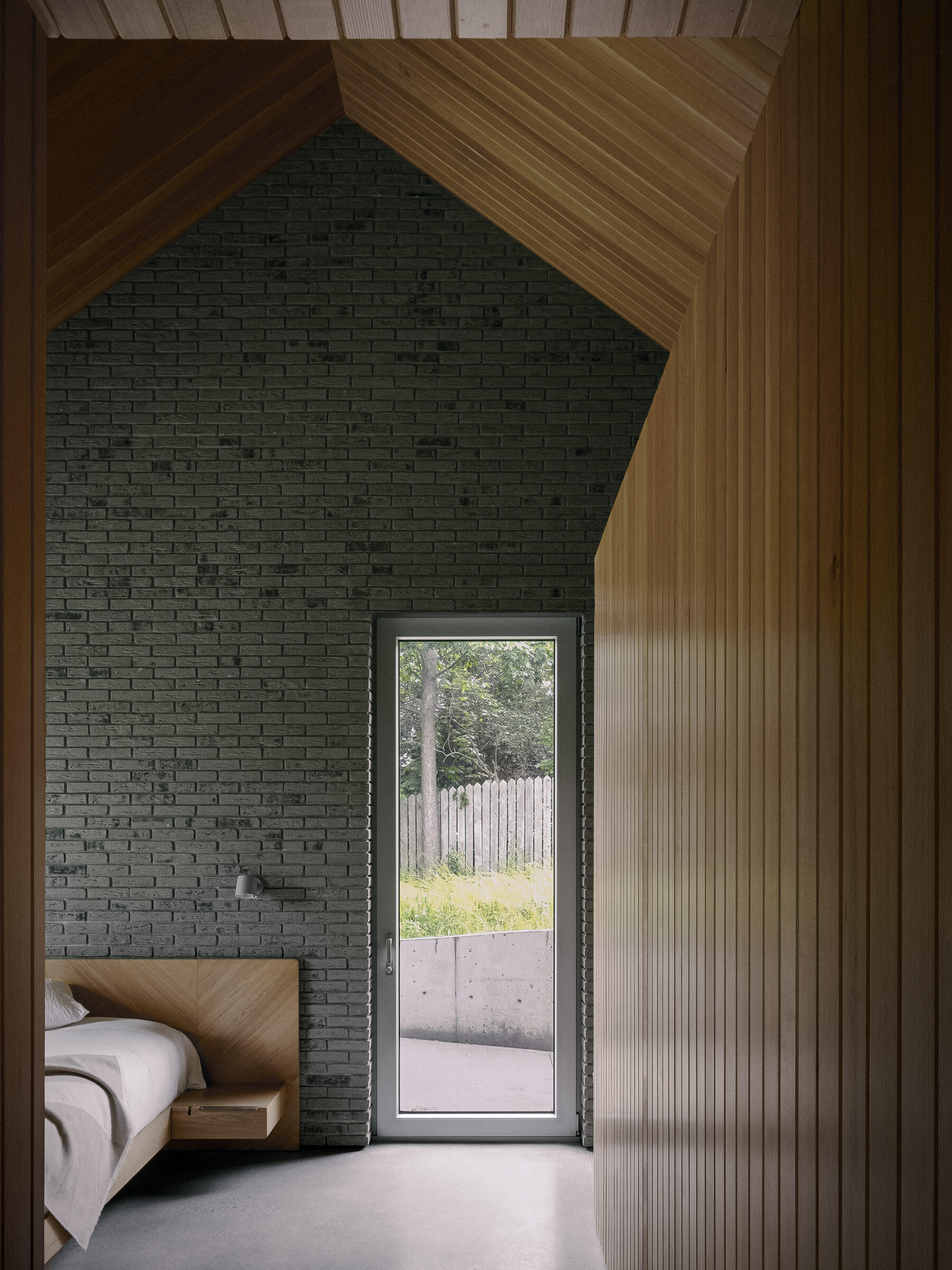 Bedroom brick wall and glazed door to the terrace